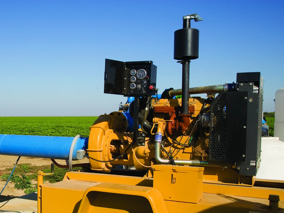 Diesel engine driven irrigation pump beside a green field