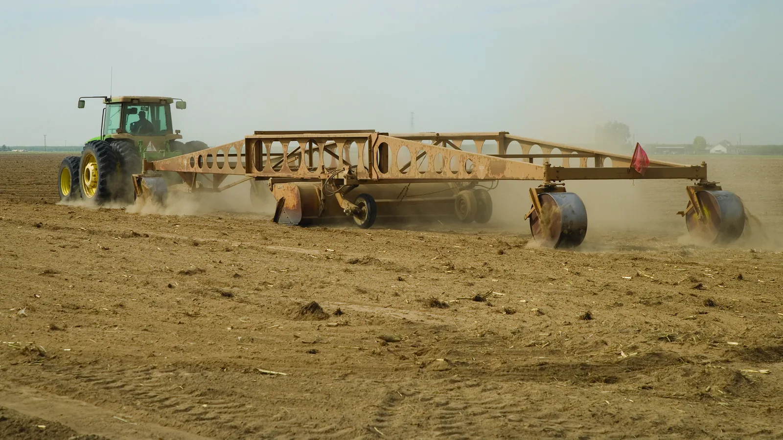 Tractor leveling a dry field for irrigation
