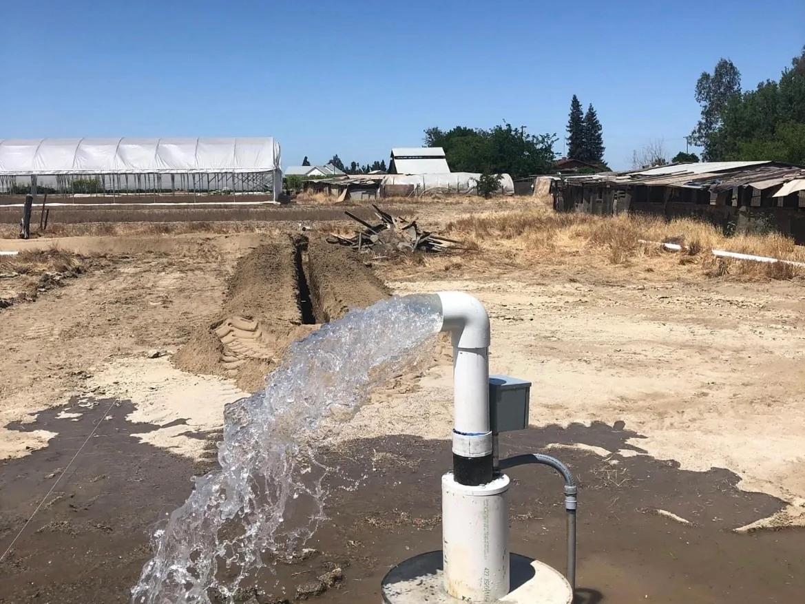 Water gushing from a new well casing during well development